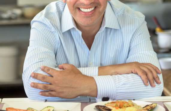 Chef posing proudly over plates of food