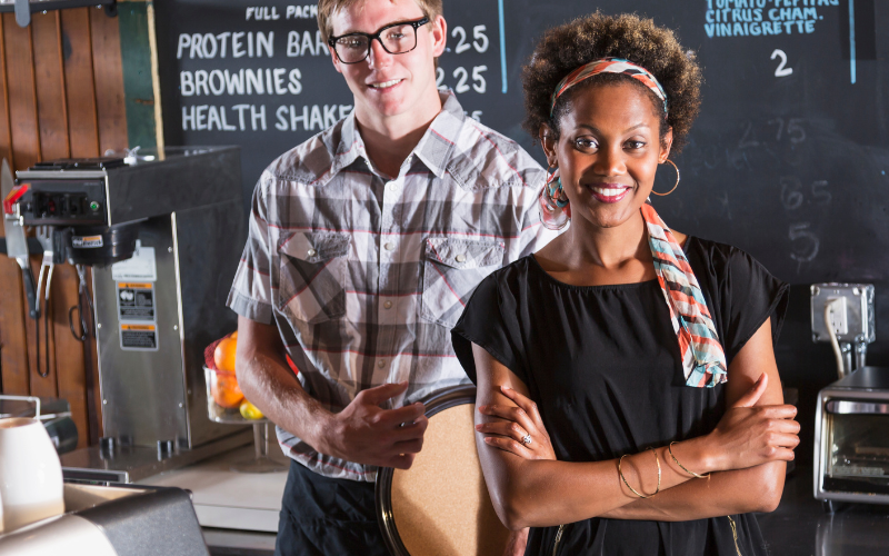 Restaurant workers standing in front of menu board