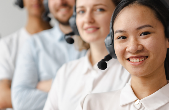 Call center workers wearing headsets standing in a row