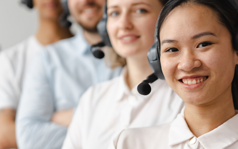 Call center workers wearing headsets standing in a row